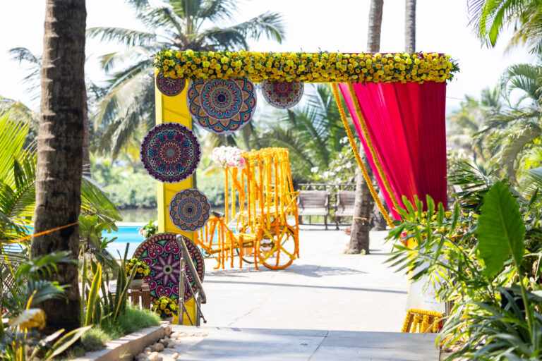 Traditional varmala moment with couple under a flower-decorated mandap at an Indian wedding ceremony