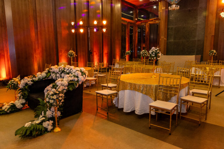 Luxury wedding reception decor with golden chairs, floral centerpieces, and elegant table settings