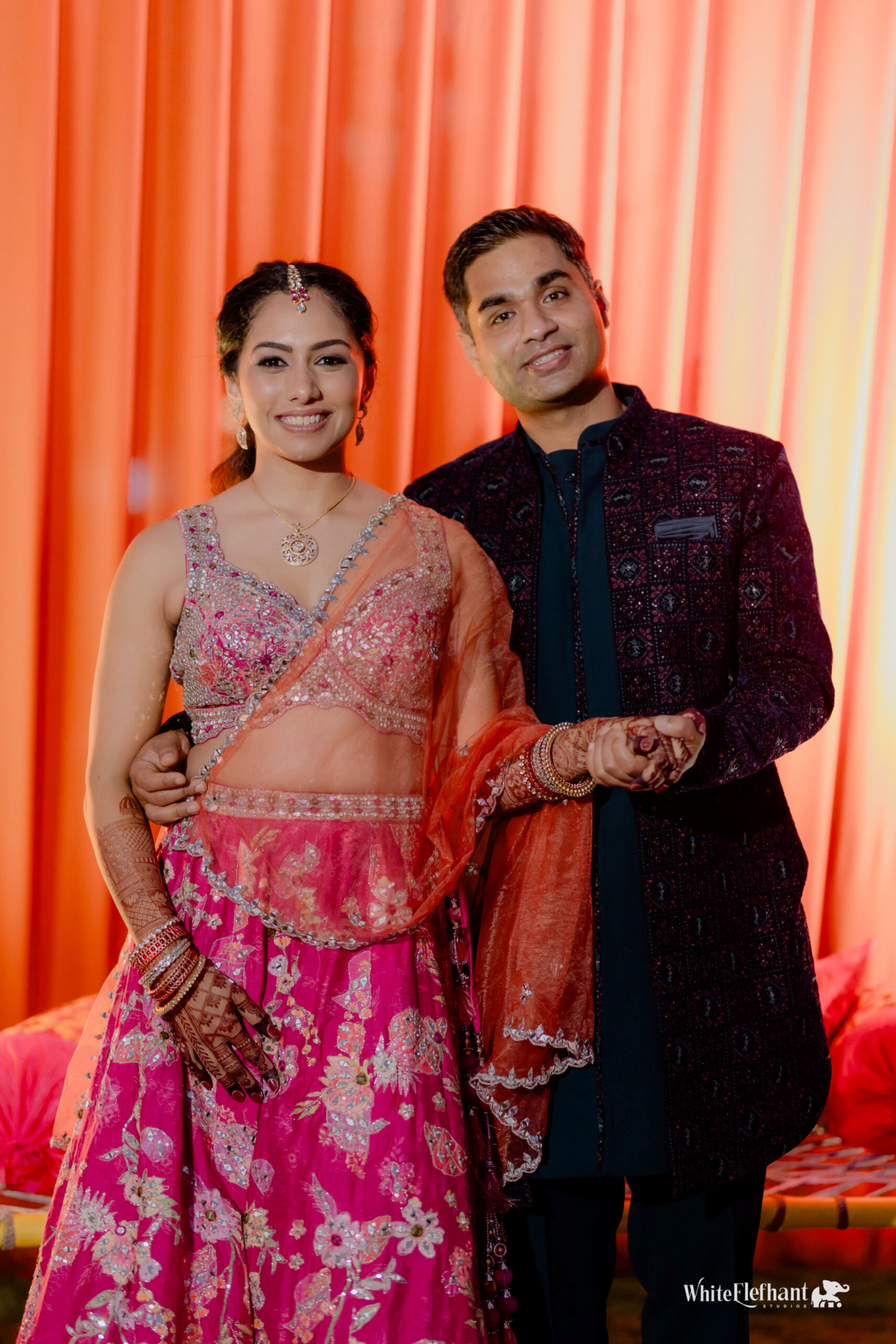 Bride and groom in traditional Indian wedding attire posing during their ceremony